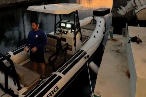 Slide: The Image of 2022 Brig Navigator 24 boat docked at sunset with a person onboard. - 30