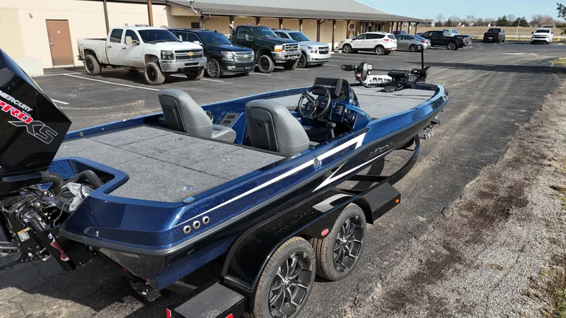 Slide: The Image of 2025 iKon VLX21 boat on trailer, parked in lot with trucks in background. - 10