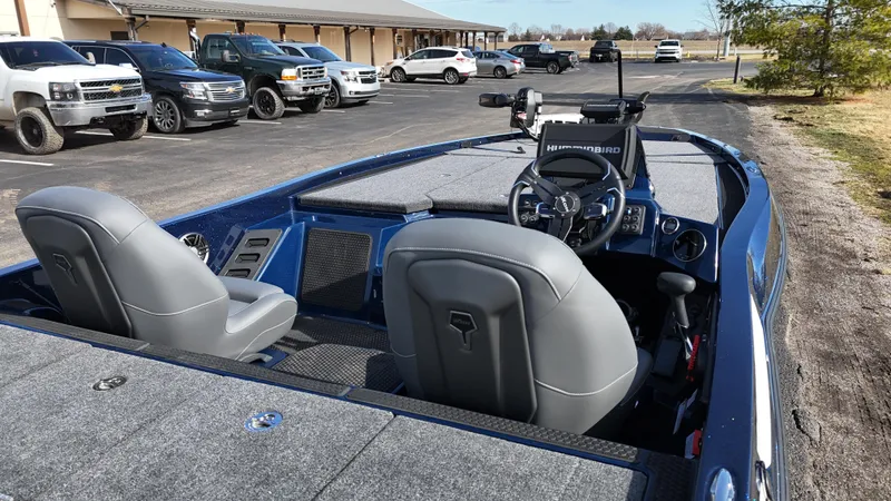 Slide: The Image of 2025 iKon VLX21 boat interior with modern dashboard and seating, parked near vehicles. - 13