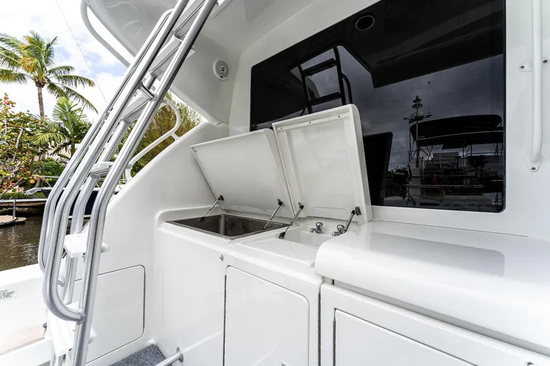 Slide: The Image of 2003 Bertram 570 Moppie yacht with open storage compartments and sleek design. - 12