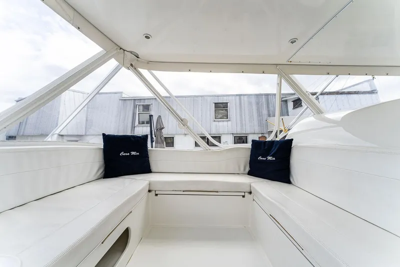 Slide: The Image of 2003 Bertram 570 Moppie boat interior with white seating and blue cushions. - 21