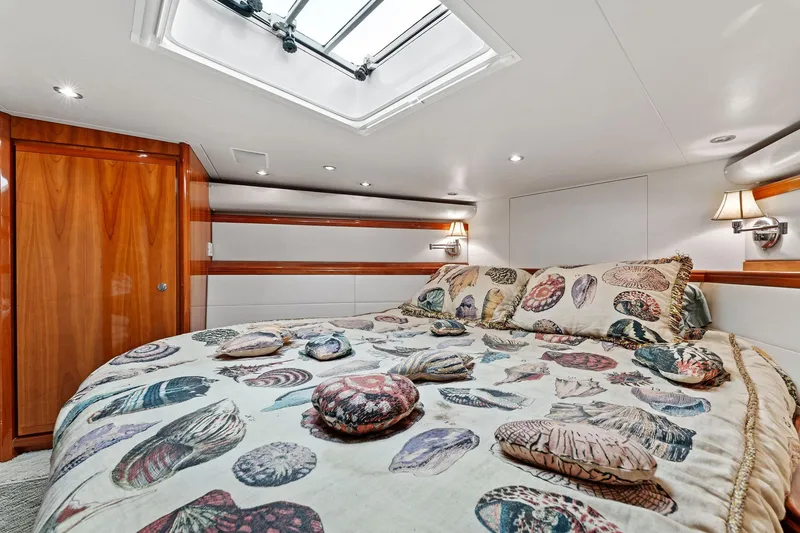 Slide: The Image of Luxurious bedroom interior of 2003 Bertram 570 Moppie yacht with skylight and shell-patterned bedding. - 36