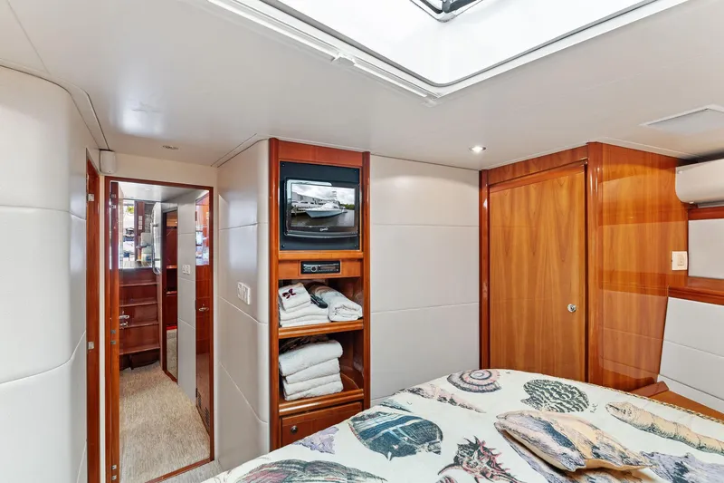 Slide: The Image of Interior of 2003 Bertram 570 Moppie yacht, featuring cozy cabin with wood accents and bedding. - 38