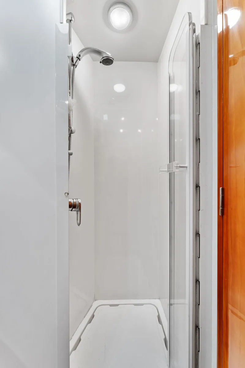 Slide: The Image of Shower area in 2003 Bertram 570 Moppie yacht, featuring sleek white design and modern fixtures. - 41
