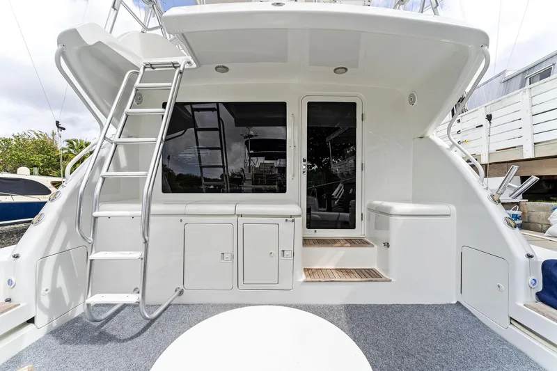 Slide: The Image of 2003 Bertram 570 Moppie yacht deck with ladder and seating area. - 7