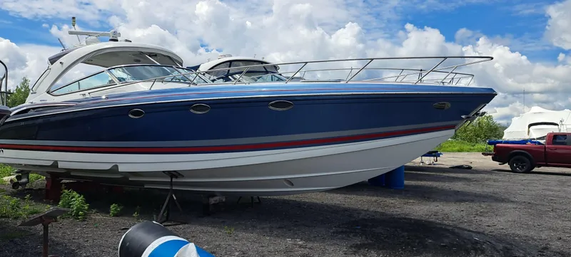 Slide: The Image of 2018 Formula 400 Super Sport boat on land, blue hull, parked near a red truck. - 3