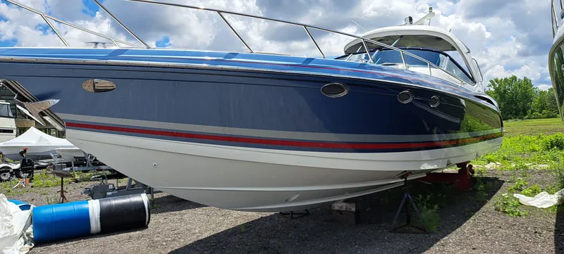 Slide: The Image of 2018 Formula 400 Super Sport boat on land, blue and white exterior, sunny day. - 4