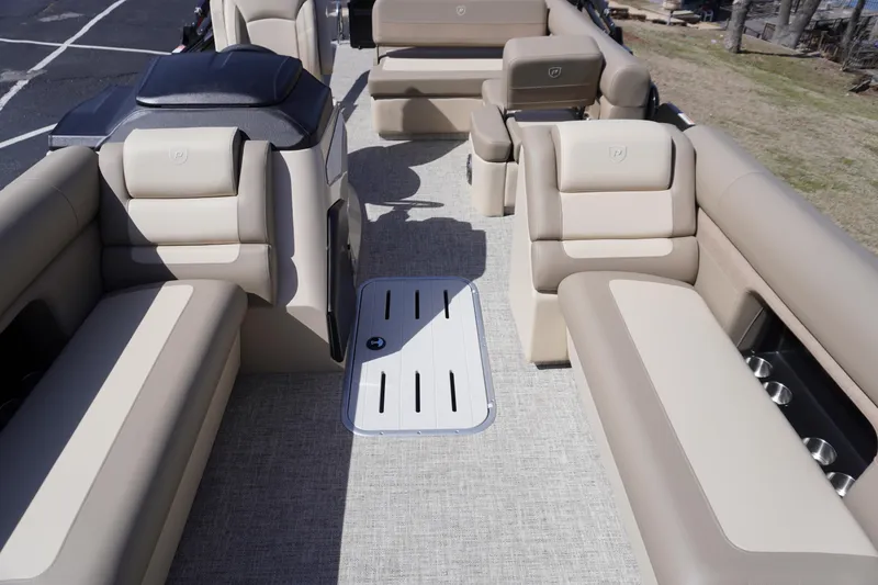 Slide: The Image of 2025 Premier 250 Sunsation RS pontoon boat interior with beige seating and spacious layout. - 10