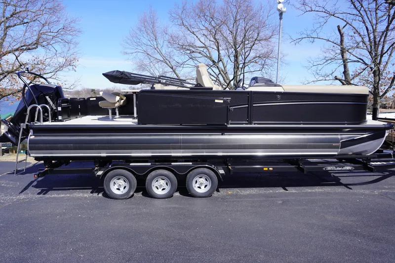Slide: The Image of 2025 Premier 250 Sunsation RS pontoon boat on a trailer, parked outdoors. - 7
