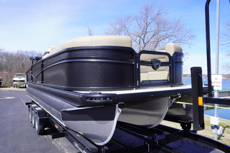 Slide: The Image of 2025 Premier 250 Sunsation RS pontoon boat on trailer, black exterior, beige seating. - 8