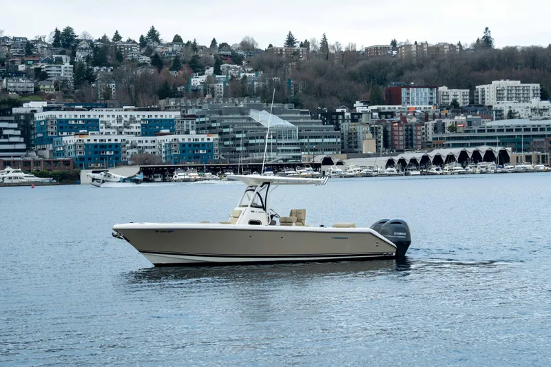 Slide: The Image of 2018 Pursuit C 260 Center Console boat on a calm urban waterfront. - 1