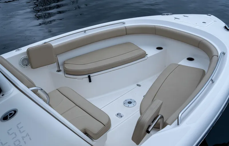 Slide: The Image of 2018 Pursuit C 260 Center Console boat with beige seating, on calm water. - 17
