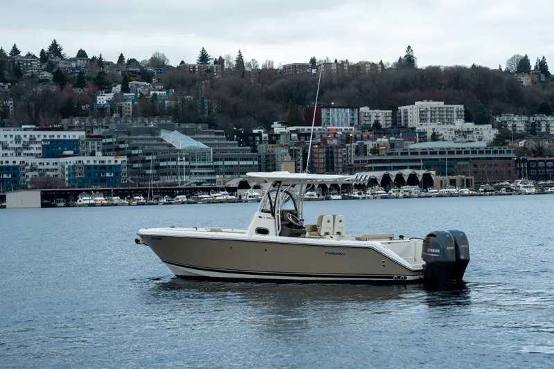 Slide: The Image of 2018 Pursuit C 260 Center Console boat on water with cityscape background. - 3