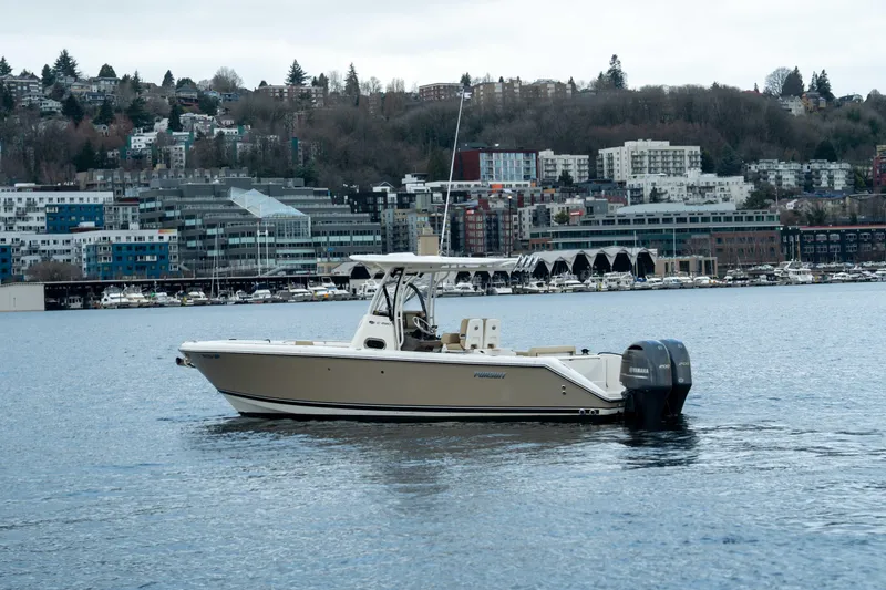 Slide: The Image of 2018 Pursuit C 260 Center Console boat on a calm urban waterfront. - 4