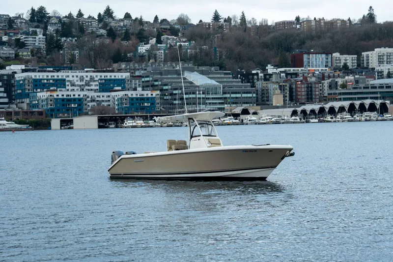 Slide: The Image of 2018 Pursuit C 260 Center Console boat on a calm urban waterfront. - 8