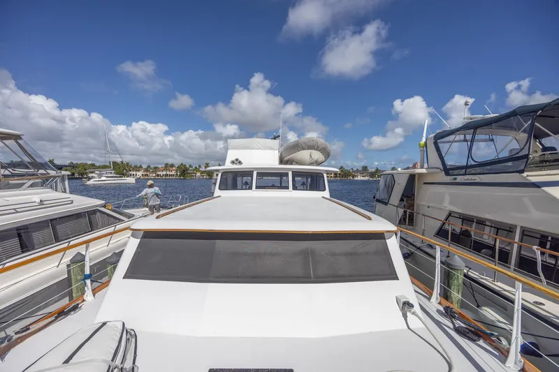 Slide: The Image of 1964 Huckins Atlantic yacht docked under a clear blue sky. - 12