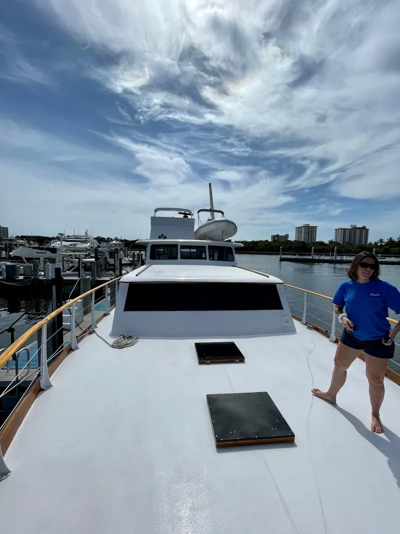 Slide: The Image of 1964 Huckins Atlantic yacht docked under a partly cloudy sky. - 13