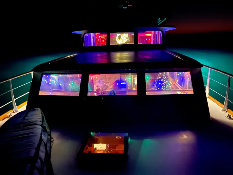 Slide: The Image of 1964 Huckins Atlantic boat with colorful interior lights at night. - 14