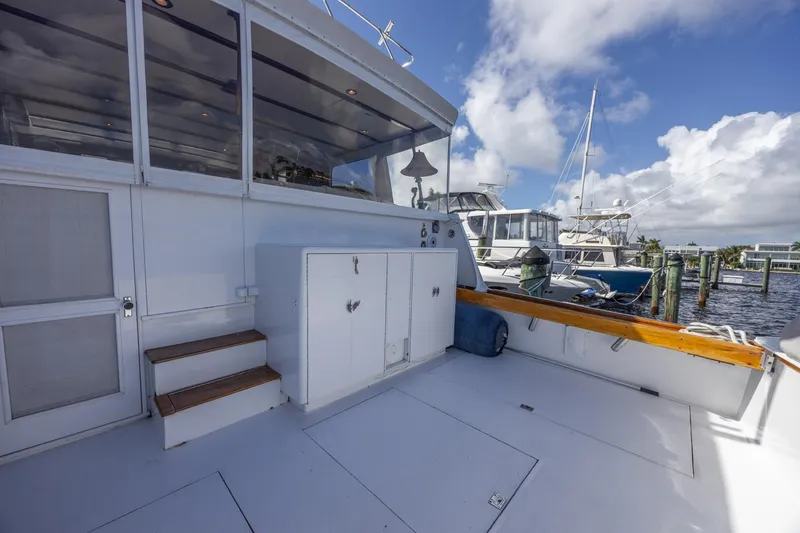 Slide: The Image of 1964 Huckins Atlantic yacht deck with storage cabinets and marina view. - 15