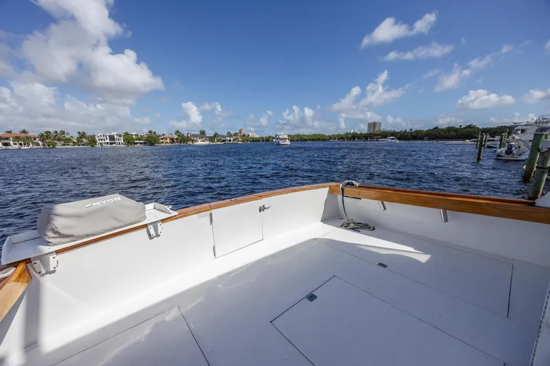 Slide: The Image of 1964 Huckins Atlantic boat deck with scenic waterfront view under blue sky. - 18