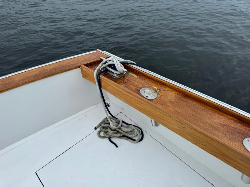 Slide: The Image of 1964 Huckins Atlantic boat deck with wooden railing and coiled rope. - 19