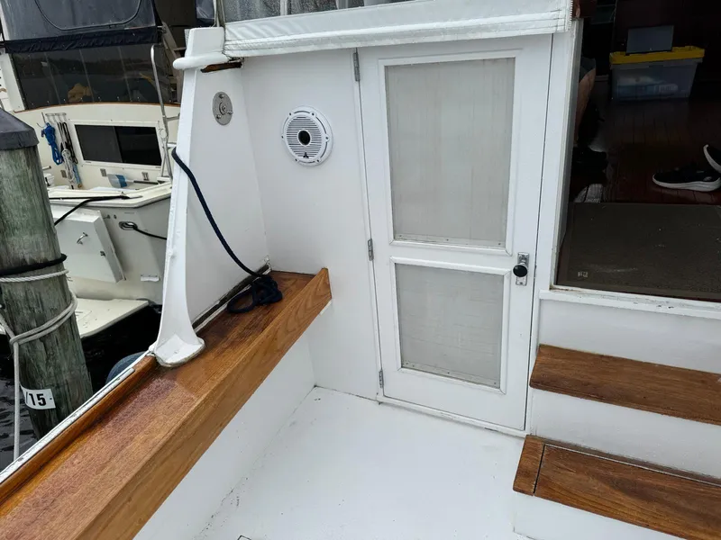 Slide: The Image of 1964 Huckins Atlantic boat deck with wooden trim and white door. - 21