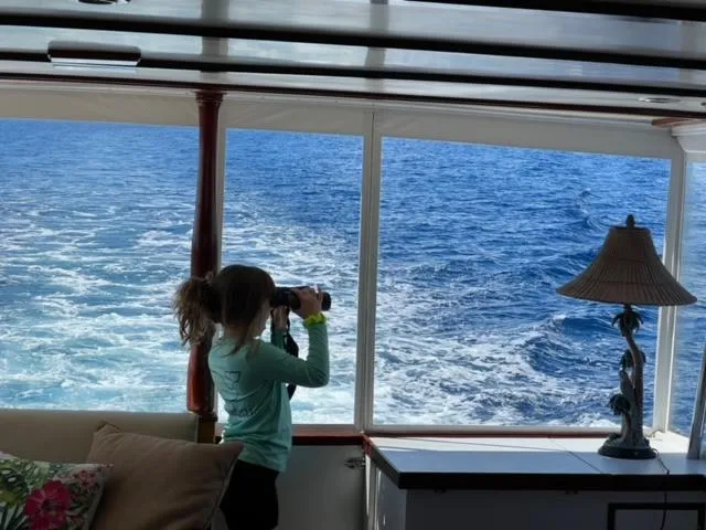 Slide: The Image of Child using binoculars on 1964 Huckins Atlantic yacht, viewing ocean through large windows. - 23