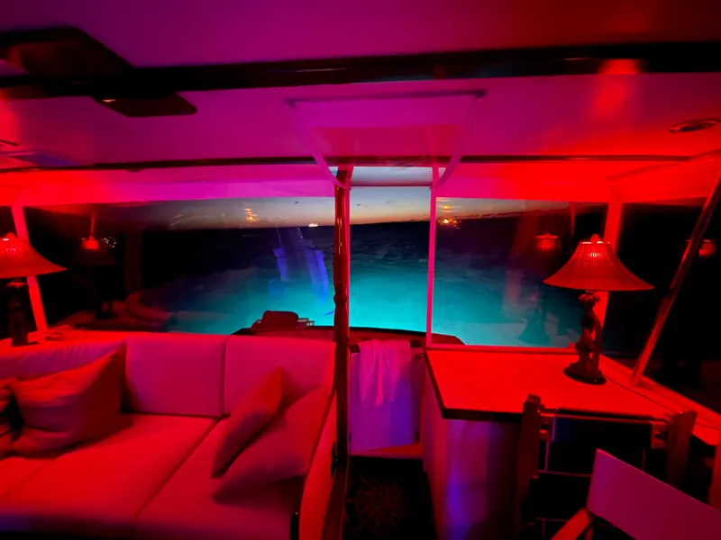 Slide: The Image of 1964 Huckins Atlantic yacht interior with red lighting and ocean view. - 24