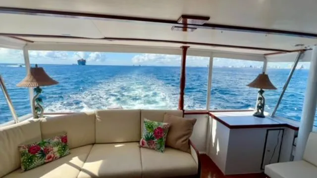 Slide: The Image of Interior view of 1964 Huckins Atlantic yacht with ocean backdrop and elegant decor. - 25