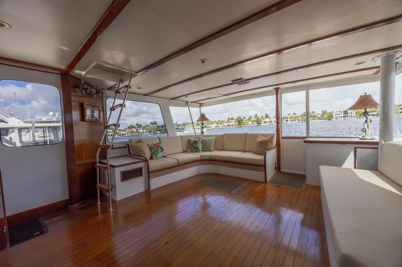 Slide: The Image of Spacious interior of a 1964 Huckins Atlantic yacht with wooden flooring and large windows. - 27
