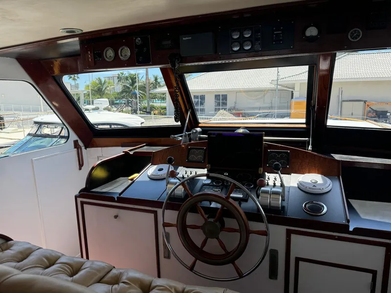 Slide: The Image of 1964 Huckins Atlantic yacht helm with classic wooden steering wheel and navigation controls. - 29