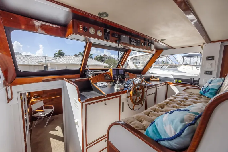 Slide: The Image of Interior of a 1964 Huckins Atlantic yacht with wooden helm and plush seating. - 33