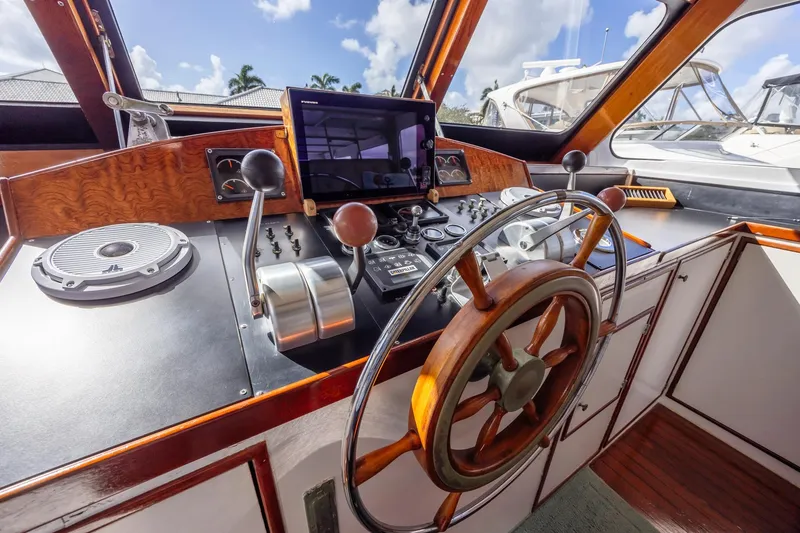 Slide: The Image of Helm of a 1964 Huckins Atlantic boat with classic wooden steering wheel. - 34