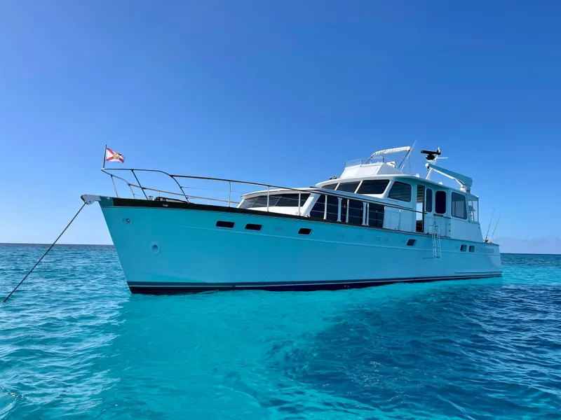 Slide: The Image of 1964 Huckins Atlantic yacht on clear blue water under a bright sky. - 4