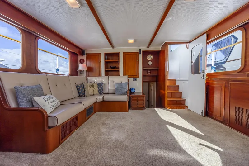 Slide: The Image of 1964 Huckins Atlantic yacht interior with plush seating, wooden accents, and nautical decor. - 42