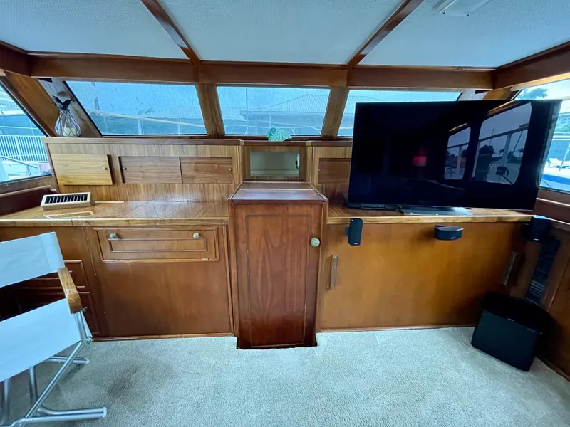 Slide: The Image of Interior of a 1964 Huckins Atlantic yacht with wood paneling and a mounted TV. - 44