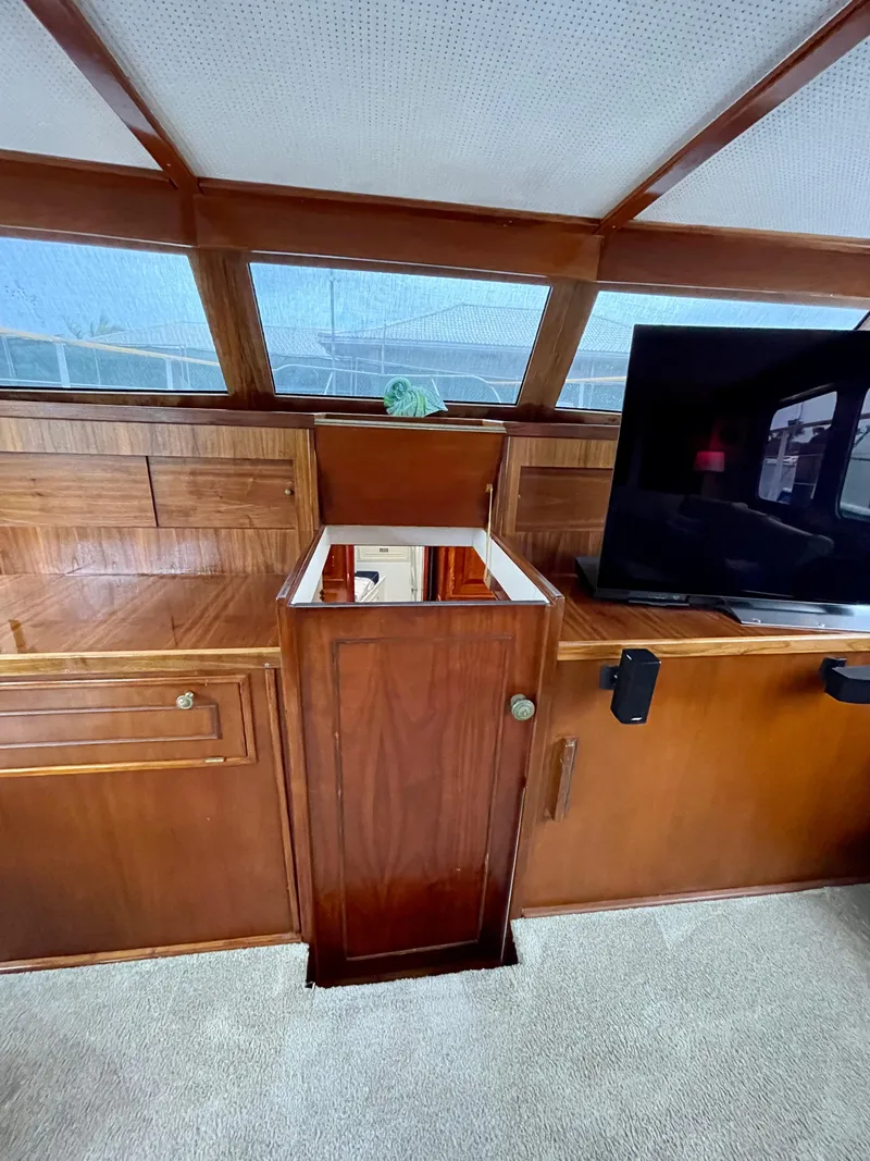 Slide: The Image of 1964 Huckins Atlantic yacht interior with wooden cabinetry and a mounted TV. - 45