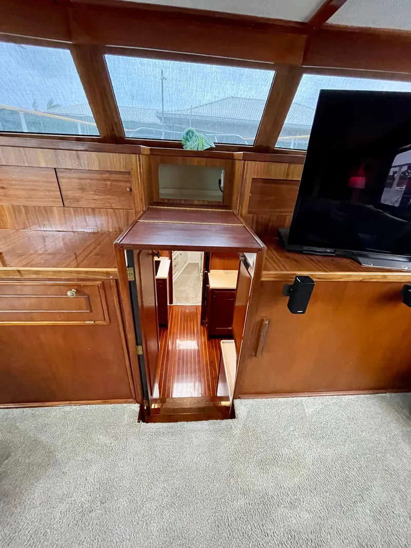 Slide: The Image of Interior of a 1964 Huckins Atlantic yacht with wooden cabinetry and a staircase. - 46