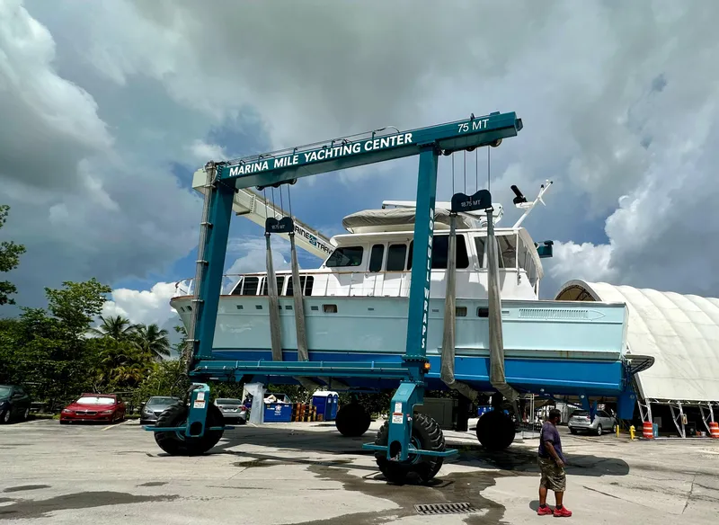 Slide: The Image of 1964 Huckins Atlantic yacht at Marina Mile Yachting Center, lifted by a large crane. - 6
