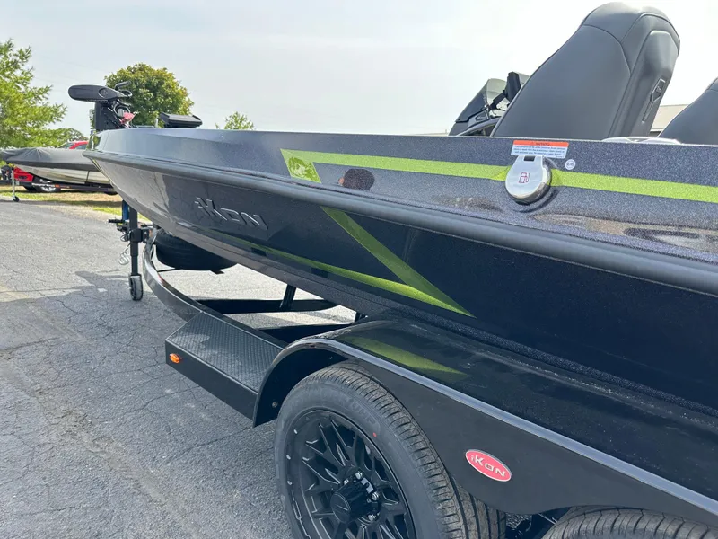 Slide: The Image of 2025 iKon VLX20 boat on trailer, black with green accents, parked outdoors. - 10