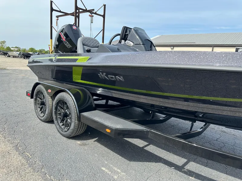 Slide: The Image of 2025 iKon VLX20 boat on trailer, sleek design, black and green accents. - 19