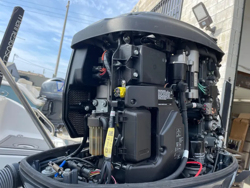 Slide: The Image of Close-up of a 2021 Sea Hunt Ultra 219 boat engine, showcasing intricate mechanical components. - 21