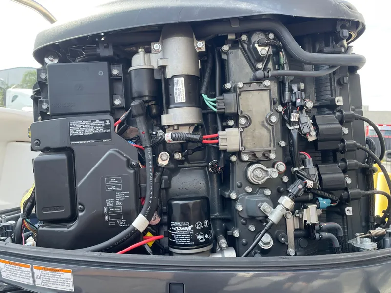 Slide: The Image of 2021 Sea Hunt Ultra 219 engine close-up, showcasing intricate mechanical components and wiring. - 25