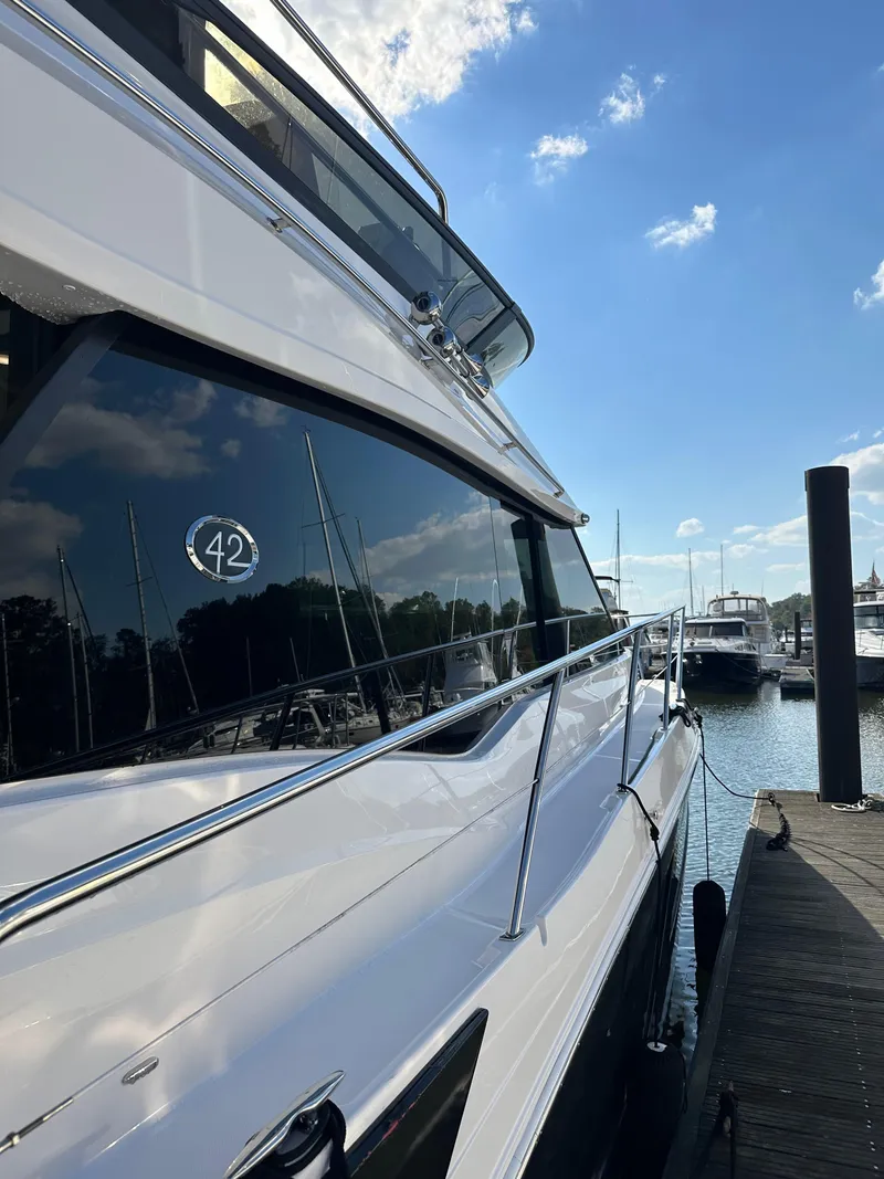 Slide: The Image of 2021 Regal 42 FXO yacht docked at marina under blue sky. - 10