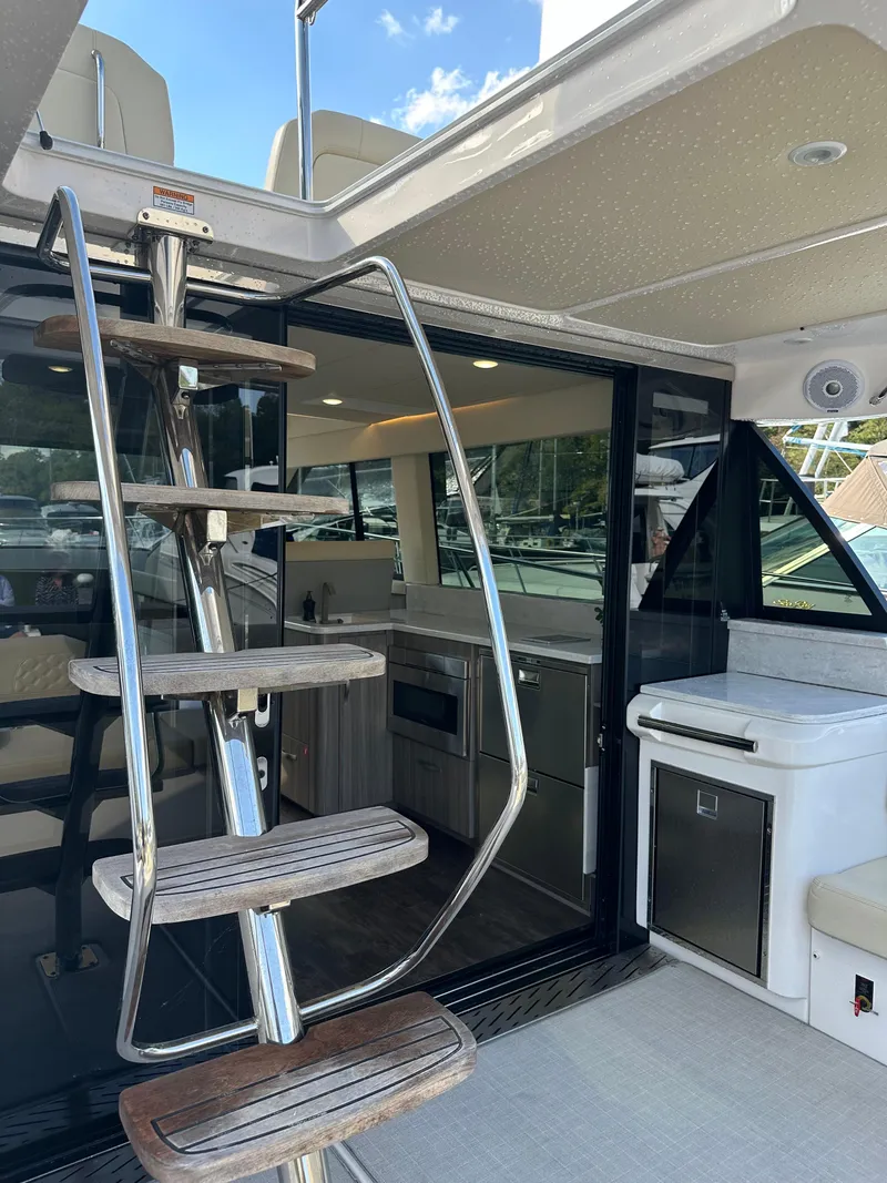 Slide: The Image of 2021 Regal 42 FXO yacht interior with modern kitchen and spiral staircase. - 16