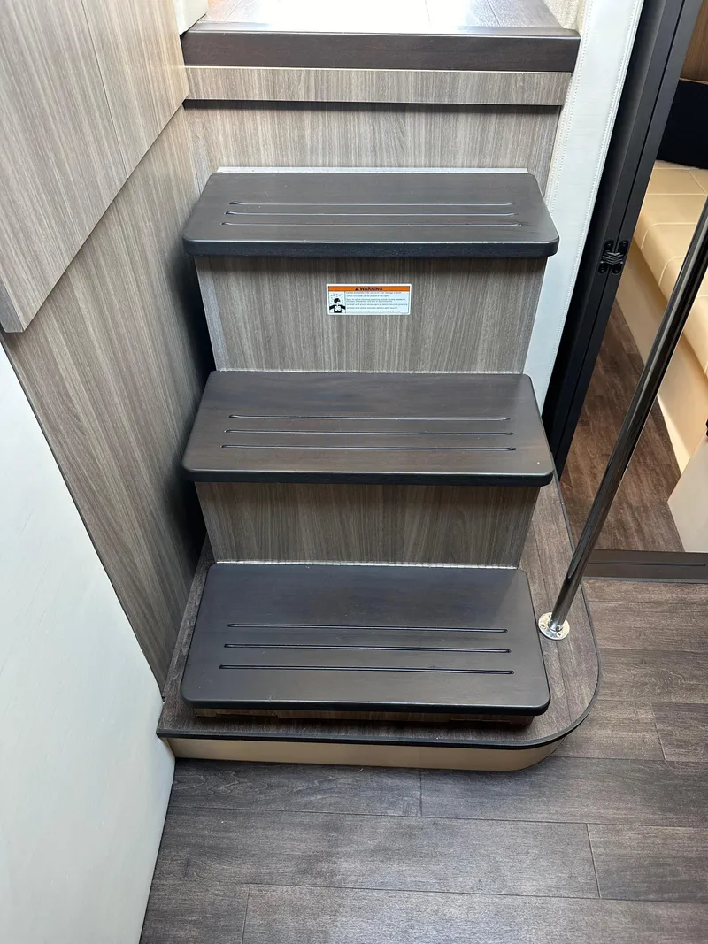 Slide: The Image of 2021 Regal 42 FXO interior stairs with wood finish and metal railing. - 31