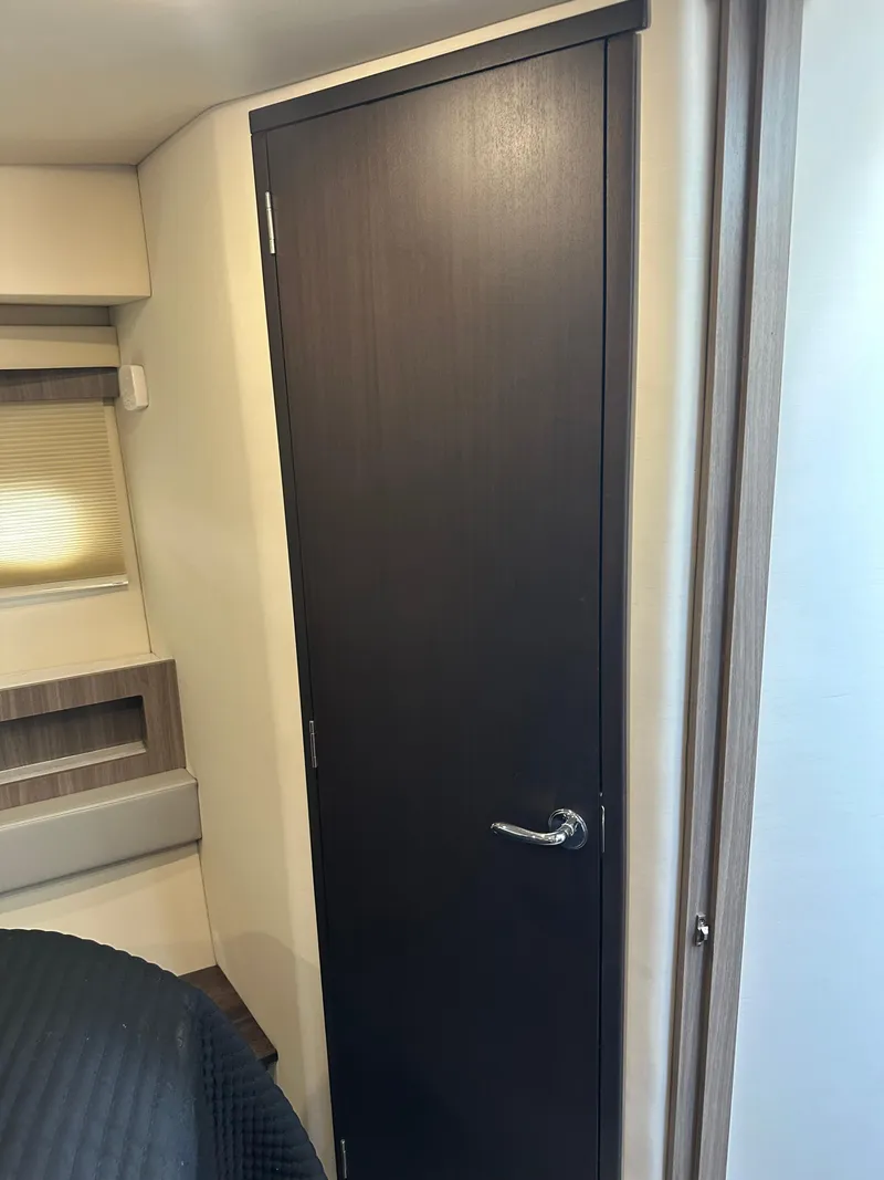 Slide: The Image of Interior of 2021 Regal 42 FXO yacht, featuring a sleek wooden door. - 35