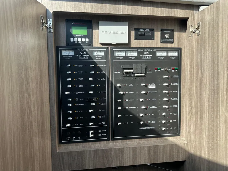 Slide: The Image of Electrical control panel inside a 2021 Regal 42 FXO boat, featuring various switches and displays. - 42