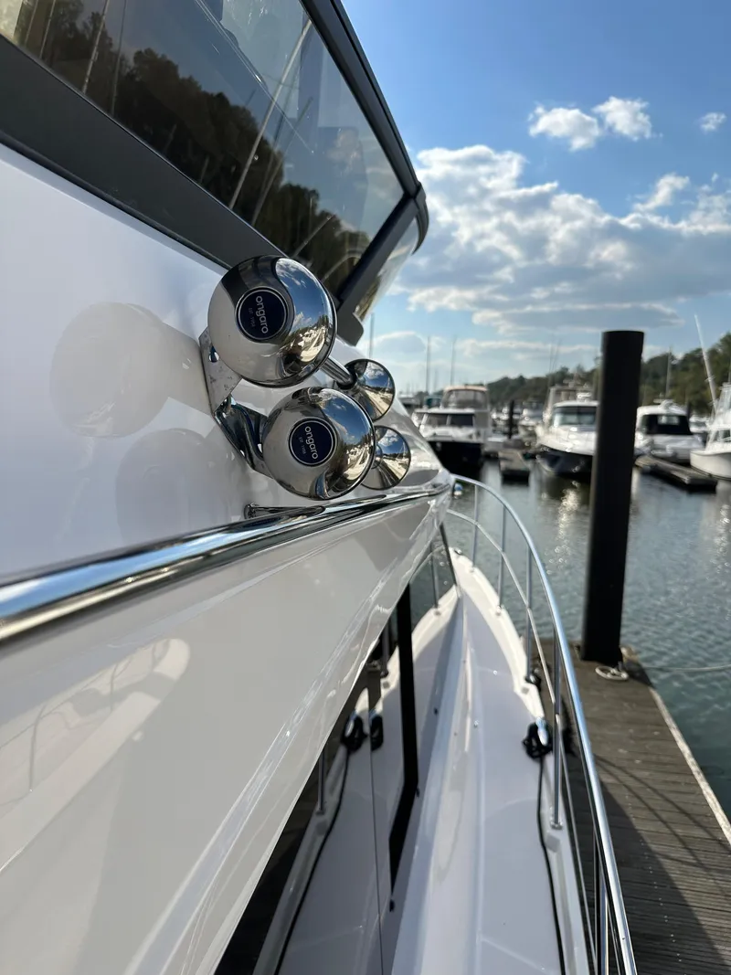 Slide: The Image of 2021 Regal 42 FXO yacht docked at marina, showcasing sleek design and chrome details. - 7