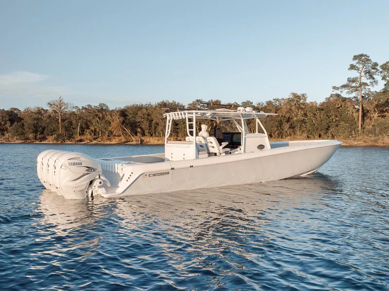 Slide: The Image of 2021 Contender 44 ST boat on calm water, featuring triple Yamaha outboard engines. - 10